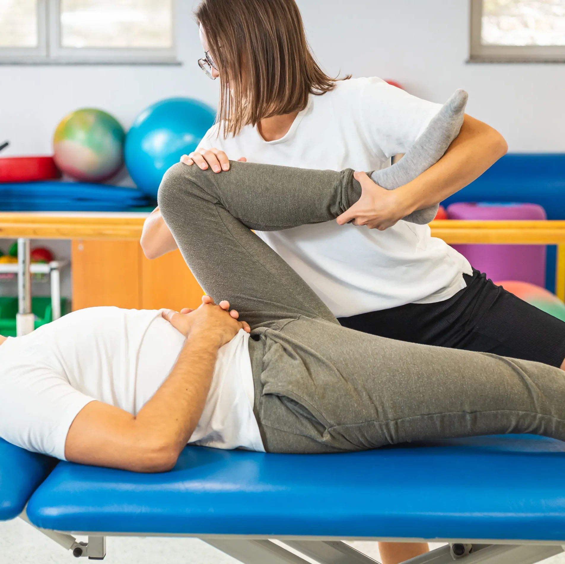 physiotherapist stretching her patient's hamstring to help with sciatica pain